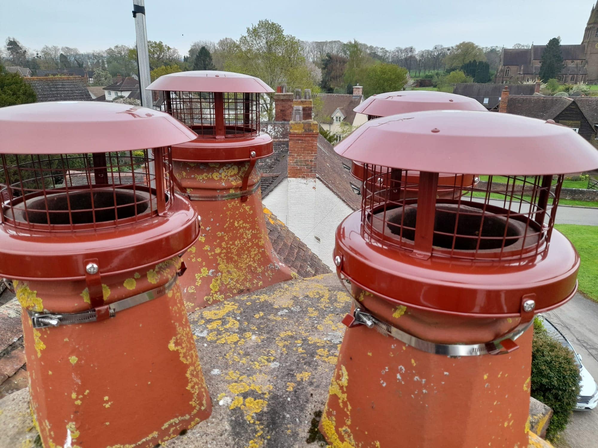 The same chimney pots with red cowls fitted