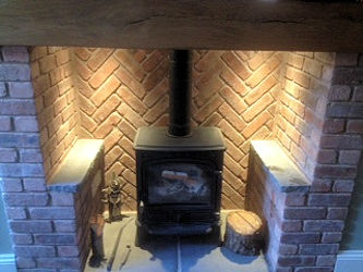 Fireplace with a herringbone brick back, slate hearth and wood burner
